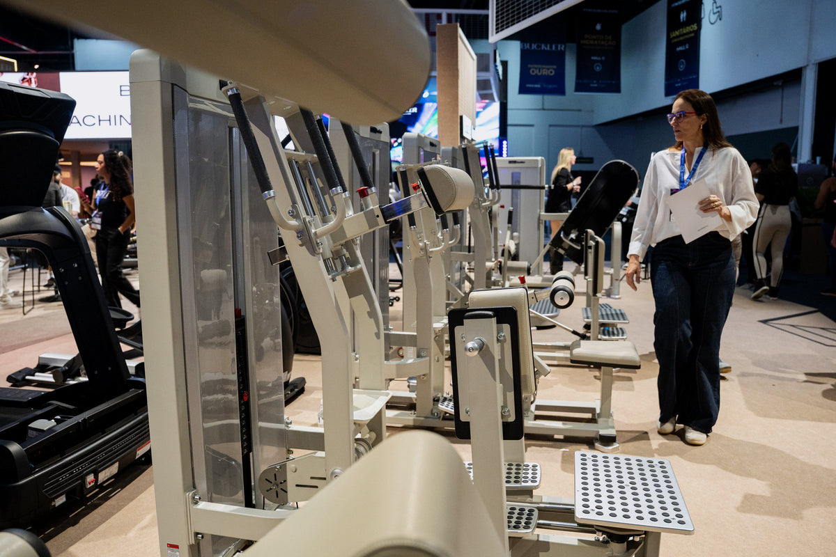 A visitor examining the Gluteleader equipment range at the fitness expo